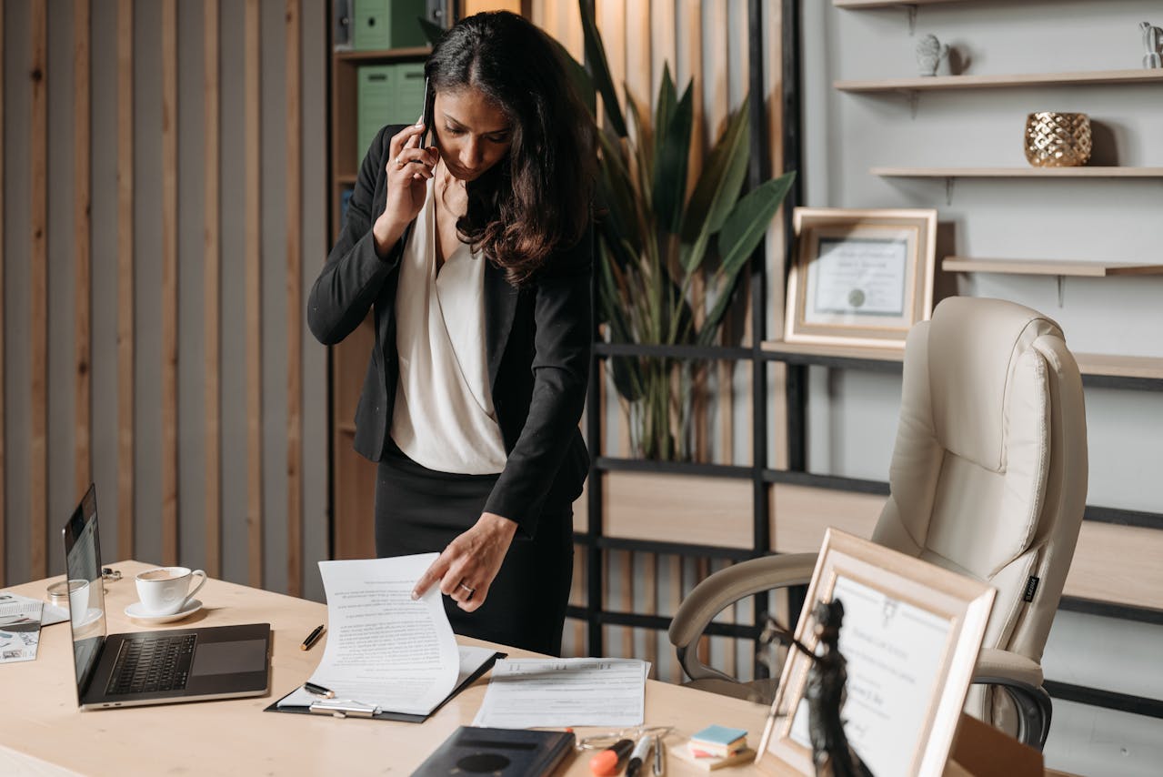 person-talking-on-phone-and-looking-at-papers person-talking-on-phone-and-looking-at-papers