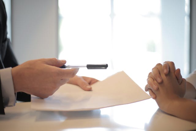 one-person-holding-pen-and-peper-other-person-with-hands-crossed